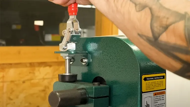 Close-up of a Grizzly 2” x 48" 2-Wheel Belt Grinder/Sander with a hand operating the red lever