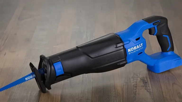 A blue and black Kobalt 24-Volt Max-Volt Variable Speed Cordless Reciprocating Saw with a blade, sitting on top of a wooden table