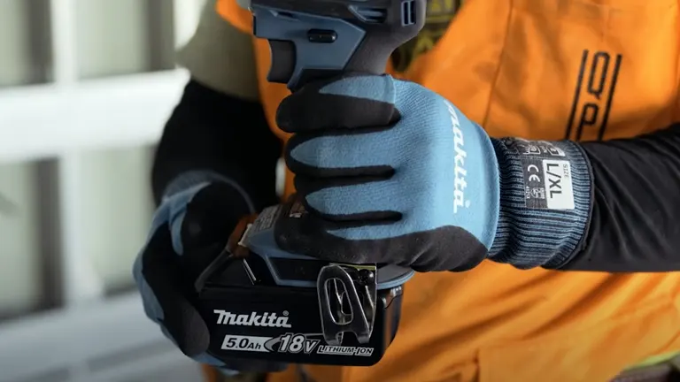 Person holding Makita 18V XDT19 Brushless Cordless Impact Driver at a construction site.