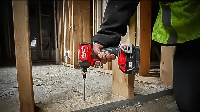 Person using a red power drill at a construction site