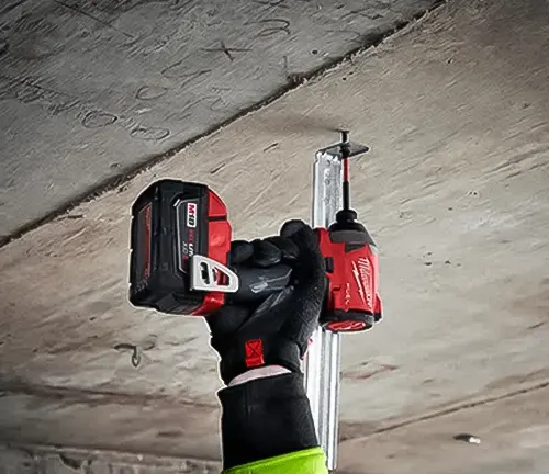 Gloved hand holding a Milwaukee T32196R M18 Recon BL Hex Impact Driver