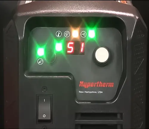 Close up of a welding machine control panel with green lights and a dial