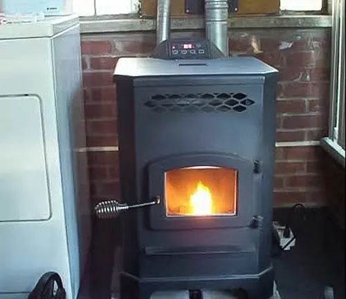Black wood-burning stove with a fire inside in a room with brick walls.