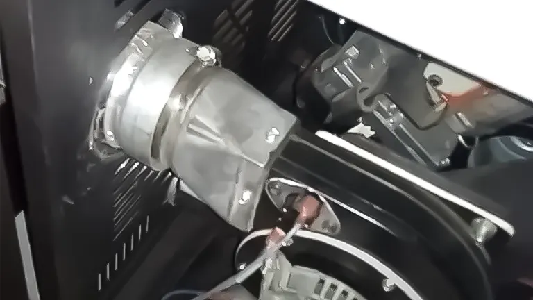 Silver motor attached to black machine.
