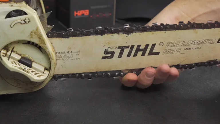 Hand demonstrating incorrect tension on a STIHL chainsaw chain