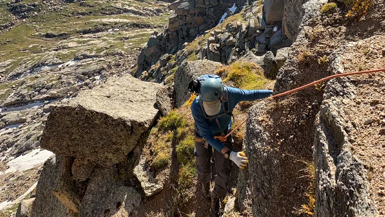 Climber ascending a rugged and rocky mountainside