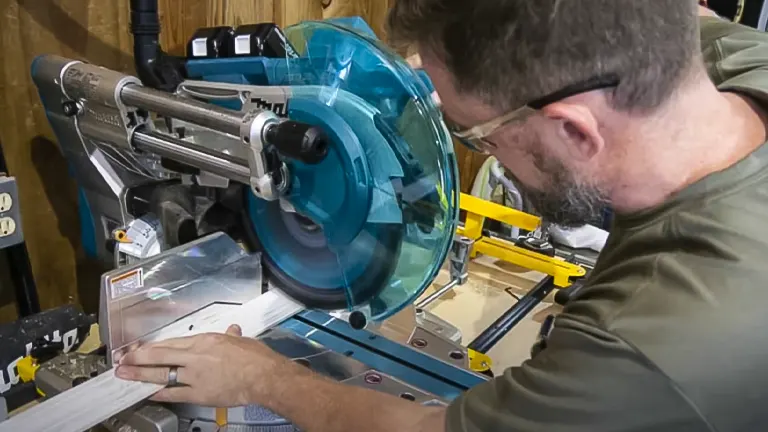 A person using a Makita 36V LXT Brushless 12" Dual-Bevel Sliding Compound Miter Saw with Laser Kit in a workshop