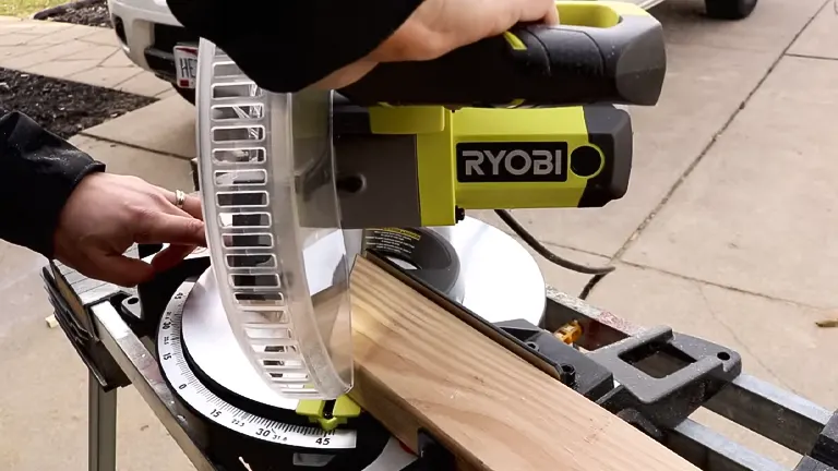 Ryobi TS1346 10” Sliding Compound Miter Saw with LED cutting a wooden plank
