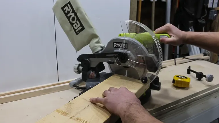 Ryobi TS1144 9 Amp Corded 7-1/4” Compound Miter Saw cutting a wooden plank in a workshop