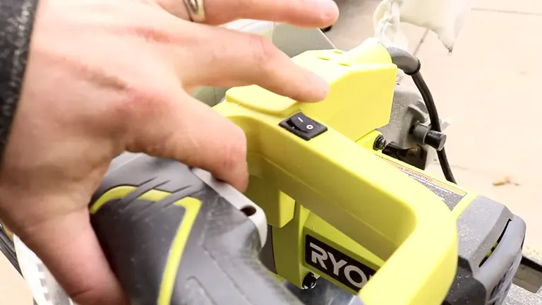Person operating a Ryobi TS1346 10” Sliding Compound Miter Saw with LED in a workshop
