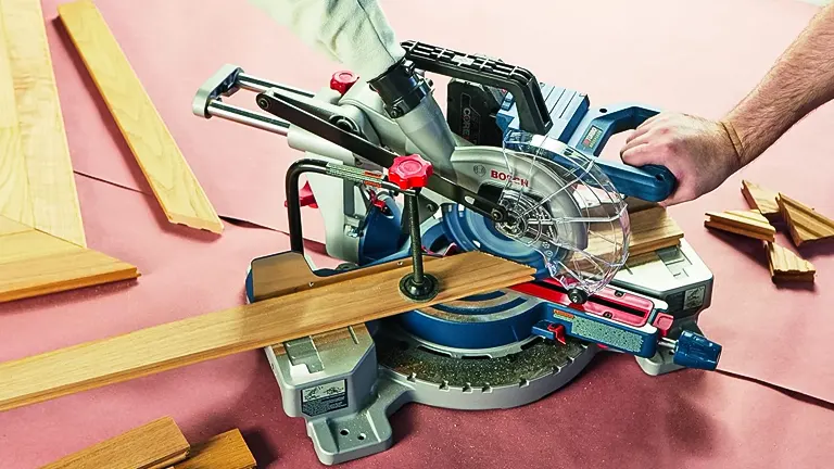Person using a BOSCH GCM18V-07SN PROFACTOR 7-1/4” Single-Bevel Slide Miter Saw to cut a wooden plank in a workshop