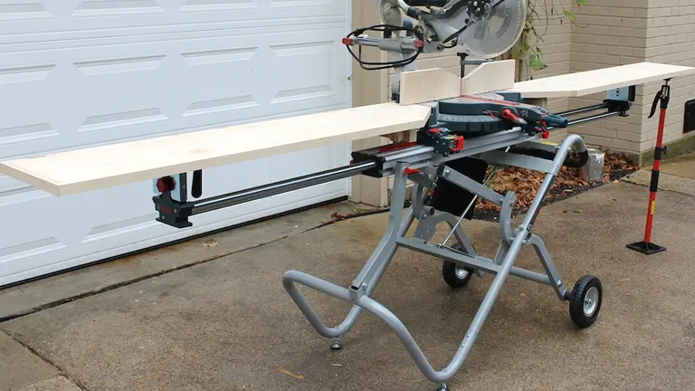 Bosch Portable Gravity-Rise Wheeled Miter Saw Stand in front of a garage door