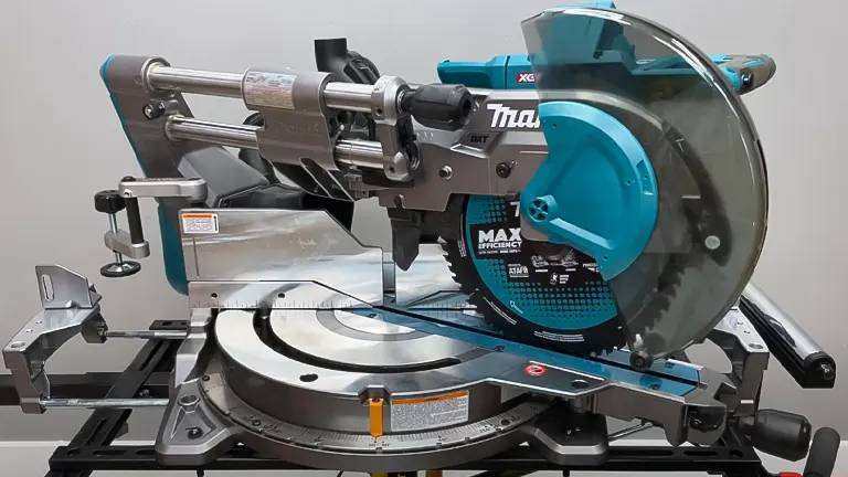 Makita 40V Max XGT 12” Dual-Bevel Sliding Compound Miter Saw with blue and silver components, positioned on a stand