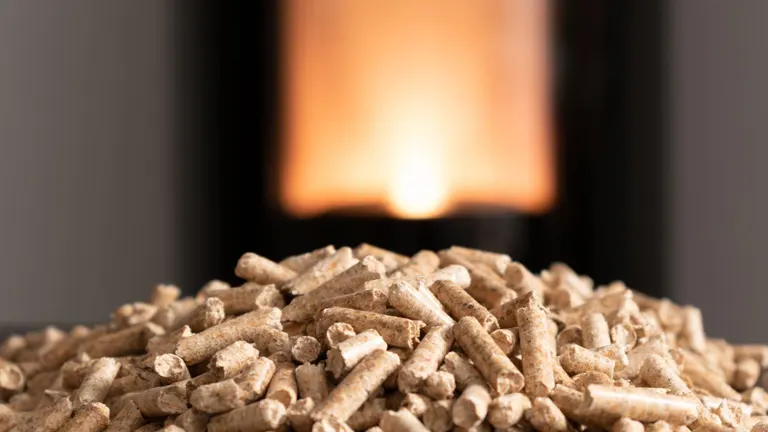 A pile of wood pellets with a glowing fire in the background