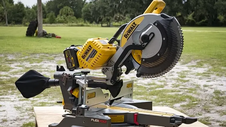 DeWalt miter saw on a wooden table in a field, ready for adjustment