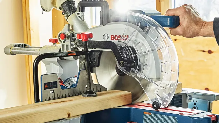 Person using a BOSCH PROFACTOR 18V 10” Dual-Bevel Slide Miter Saw to cut wood