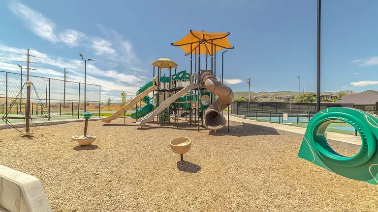 Playground with play structures on wood chips under a clear sky