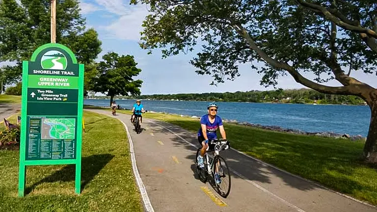 Cyclists riding along the Shoreline Trail at Niagara Falls State Park with a view of the river