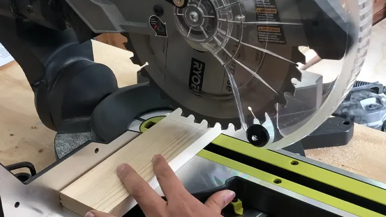 Person operating a miter saw in a workshop