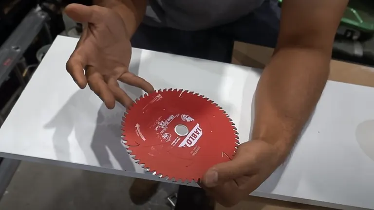 Person holding a red circular saw blade for making clean cuts