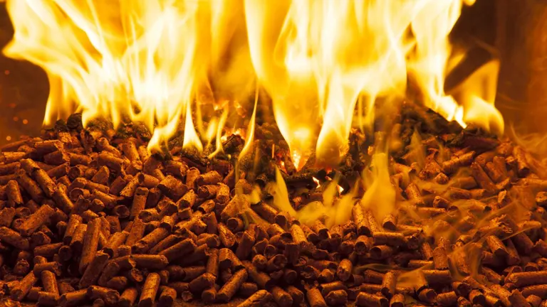 Flames burning over a pile of wood pellets