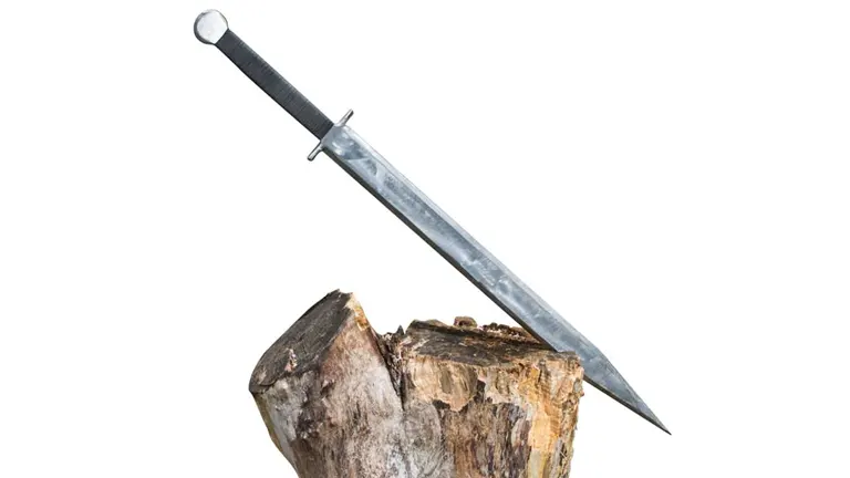 Viking wood splitter with a long, slender, pointed metallic blade, embedded in a large piece of wood