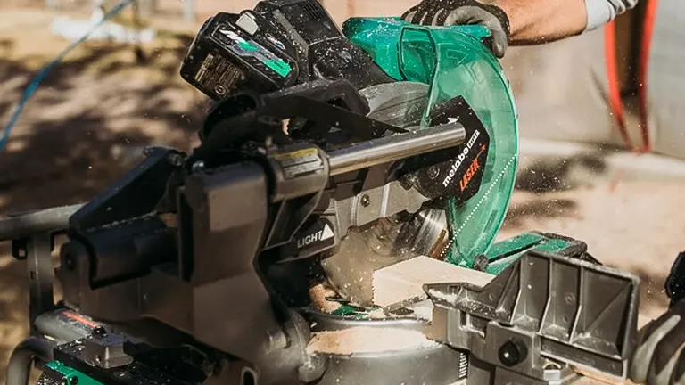 Person using a Metabo HPT 36V MultiVolt 10” Dual-Bevel Sliding Miter Saw to cut wood, creating sawdust