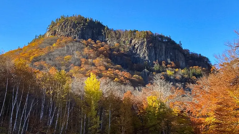 Autumn foliage at the base of a rocky peak in White Mountain National Forest
