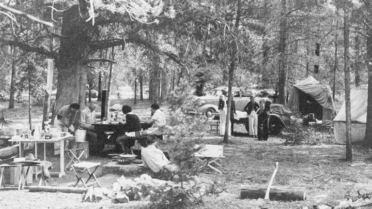 Vintage camping scene with equipment and car in Shoshone National Forest