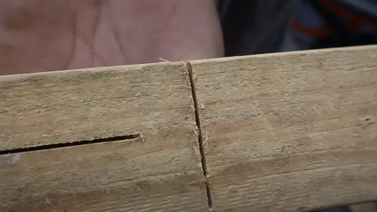 Close-up of a precise cut on a light-colored wooden plank made with a circular saw