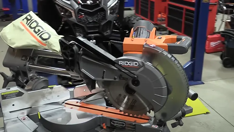 Ridgid R4210 10” Dual Bevel Sliding Miter Saw in workshop with red tool chest and black ATV