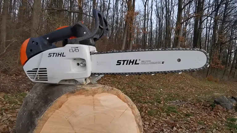 Stihl MS 151 TC E Chainsaw placed on a freshly cut log in a wooded area