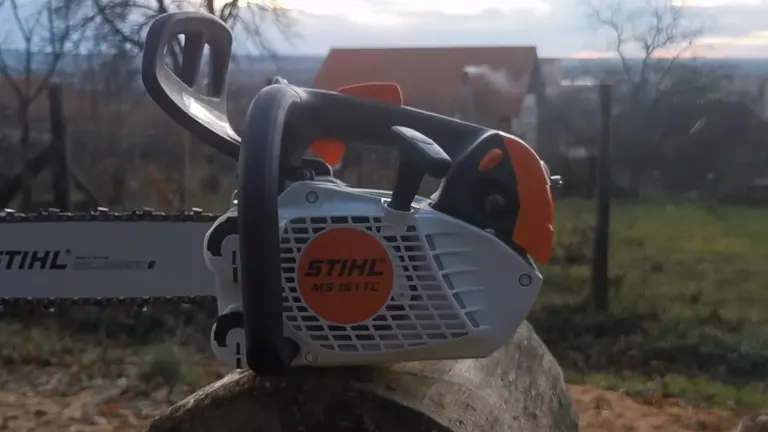 Stihl MS 151 TC E Chainsaw resting on a log in a blurred natural background
