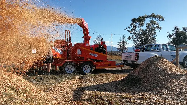 Wood chipper converting tree branches into wood chips