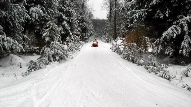 Person riding a snowmobile on a snowy trail in Allegheny National Forest