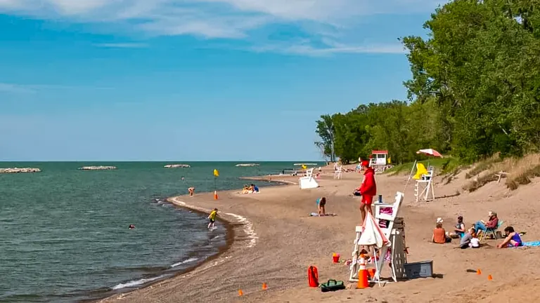 Sunny day at Presque Isle State Park beach with visitors enjoying the shore and a lifeguard on duty