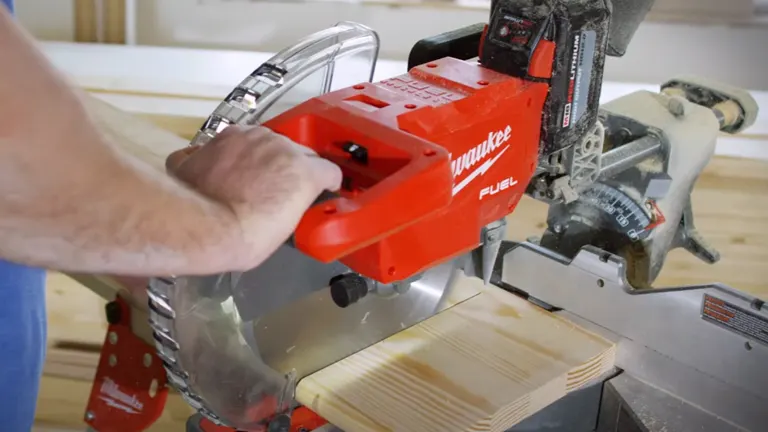 Red Milwaukee M18 FUEL 12” Dual Bevel Sliding Compound Miter Saw in use, cutting wood on a workbench