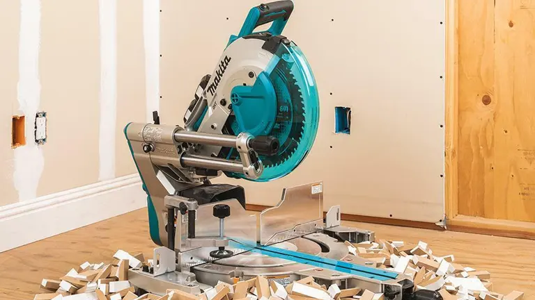 Makita 36V LXT Brushless 12” Dual-Bevel Sliding Compound Miter Saw with Laser Kit in a room with sawdust on the floor