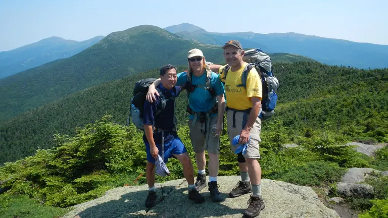Hikers in White Mountain National Forest with a scenic view of green mountains in the background
