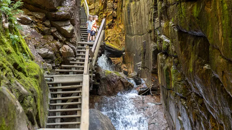 Two people observing a waterfall at Franconia Notch State Park