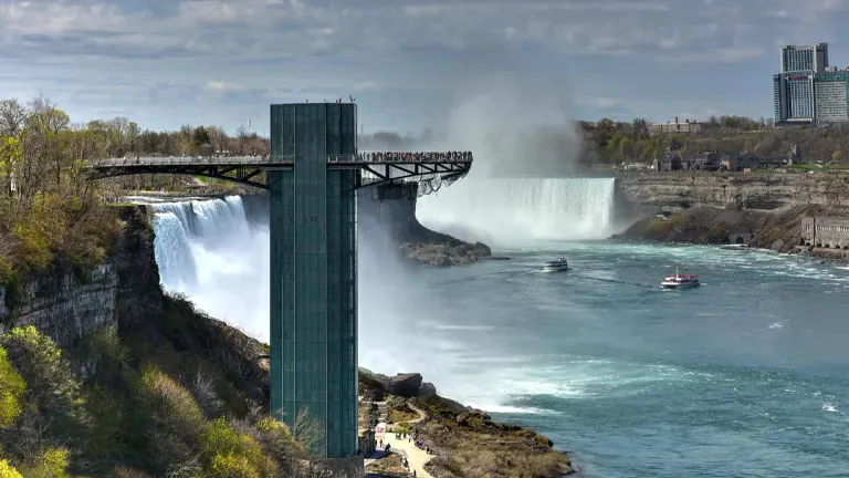 Observation tower at Niagara Falls State Park with boats navigating misty waters