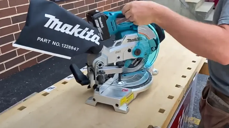 Person using a Makita 18V LXT 6-1/2” Compact Dual-Bevel Compound Miter Saw with Laser on a wooden surface