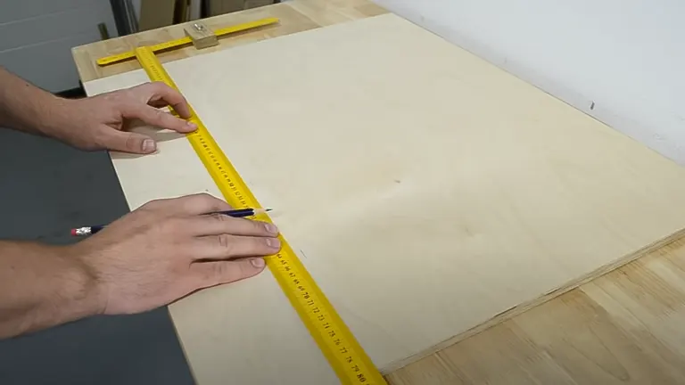 Person using a yellow ruler to measure and mark a wooden board for cutting