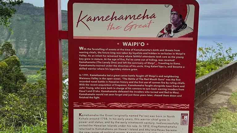 Information board about Kamehameha the Great at Akaka Falls State Park with lush greenery in the background