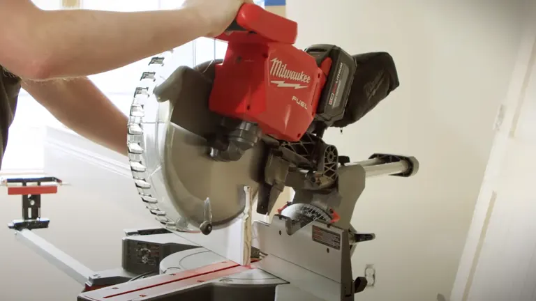 Red Milwaukee M18 FUEL 12” Dual Bevel Sliding Compound Miter Saw in action on a workbench