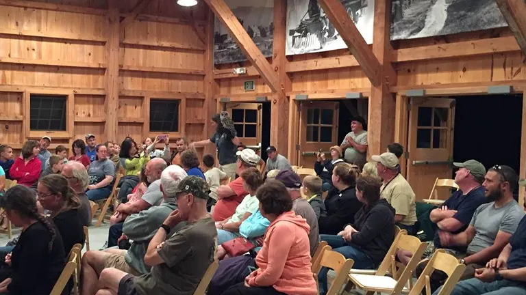 A gathering of people in a wooden cabin at White Mountain National Forest