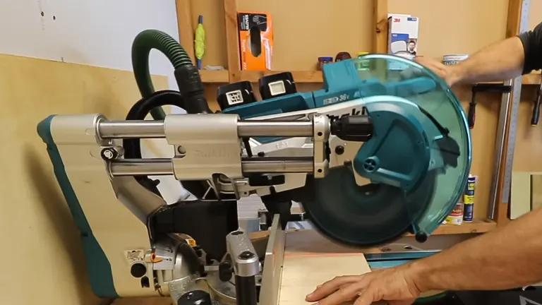 A person using a Makita XSL08PT 36V (18V X2) LXT Brushless 12” Dual‑Bevel Sliding Compound Miter Saw Kit in a workshop