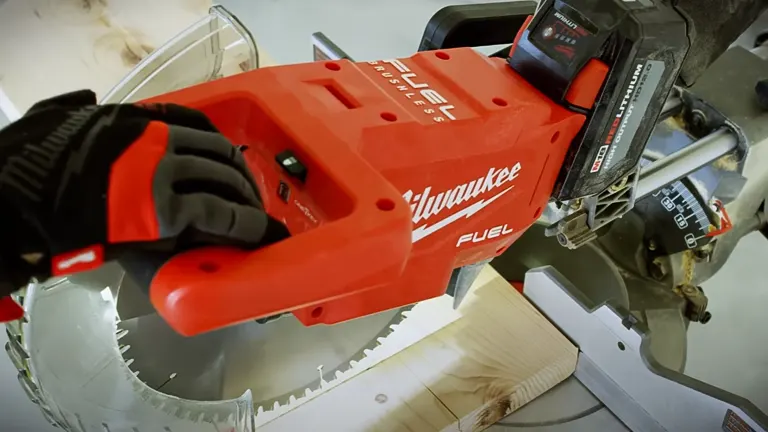 Close-up of a red Milwaukee M18 FUEL 12” Dual Bevel Sliding Compound Miter Saw cutting wood