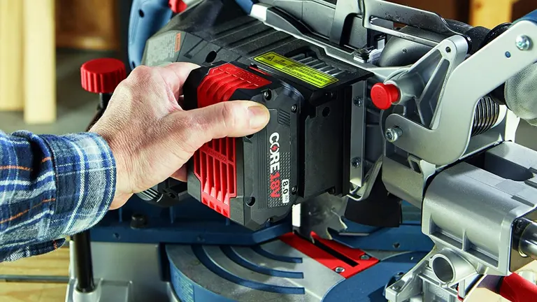 Person inserting a CORE18V battery into a BOSCH GCM18V-08N 8-1/2" Single-Bevel Slide Miter Saw