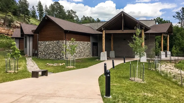 Visitor center at Custer State Park, surrounded by lush greenery under a clear blue sky